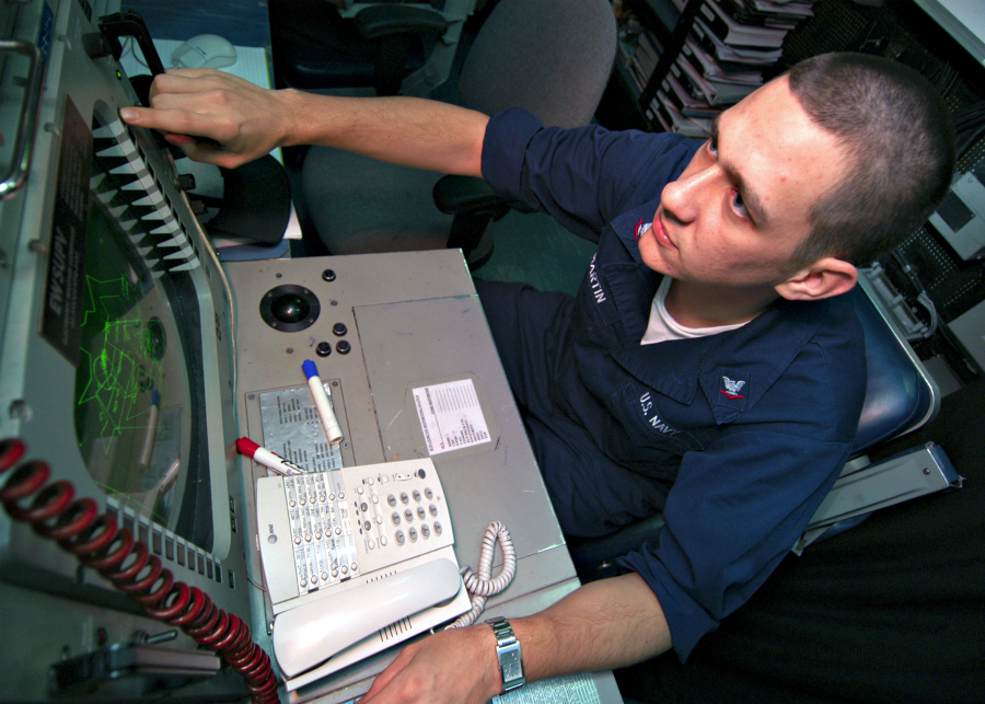031230-N-9742R-001
Arabian Gulf (Dec. 30, 2003) -- Electronic Warfare Supervisor, Crytpologic Technician 3rd Class Daniel Martin, from Bartlett, Ill., monitors the shipÕs Advanced Combat Direction System console in the Combat Direction Center (CDC) aboard USS Enterprise (CVN 65).  The Advanced Combat Direction System provides extended range display, expanded track capacity, Joint Tactical Information Distribution System interoperability, modifiable doctrine, display of mapping information, automatic gridlock, and doctrine-controlled multi-source identification.  The Enterprise Carrier Strike Group (ESG) is currently deployed conducting missions in support of Operation Iraqi Freedom and the continued war on terrorism.  U.S. Navy photo by Photographer's Mate Airman Milosz Reterski.  (RELEASED)